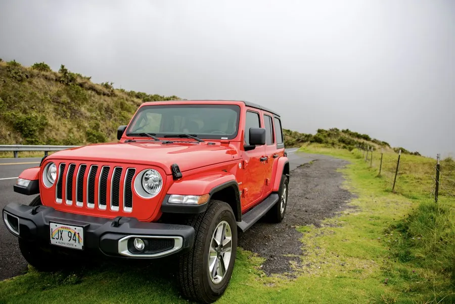 Red Jeep Wrangler on a coastal road